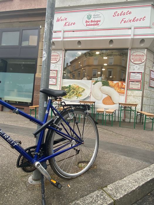 an Pfahl angeschlossenes blaues Schrottfahrrad