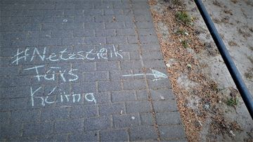 Eine Kreidebotschaft "#Netzstreik fürs Klima" ist auf einen Bürgersteig gemalt mit einem Pfeil zum rissigen, ausgetrockneten Beet-Boden daneben