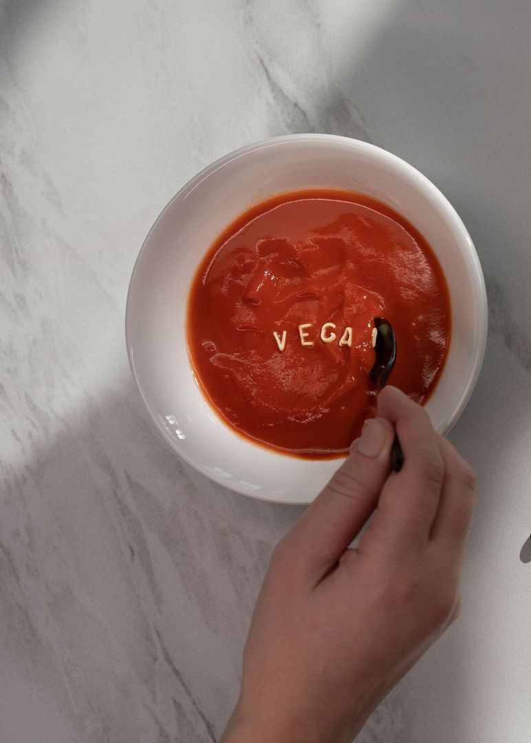 In einer weißen Schüssel ist eine rote Suppe. Daraif gelegt ist das Wort "vegan" mit Buchstabensuppen-Nudeln