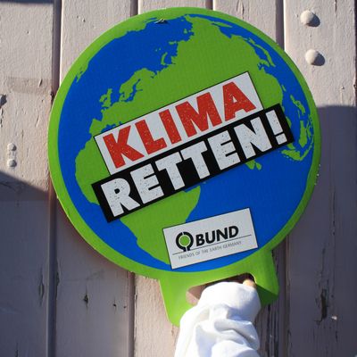 Eine Hand hält ein BUND Schild mit der Aufschrift "Klima retten".