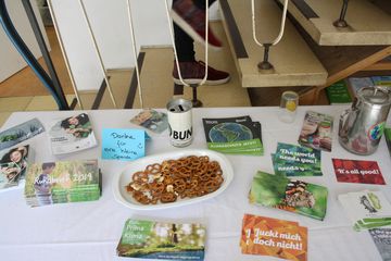 Ein Tisch mit Wasser, Gläsern, Snacks und Informations-Materialien